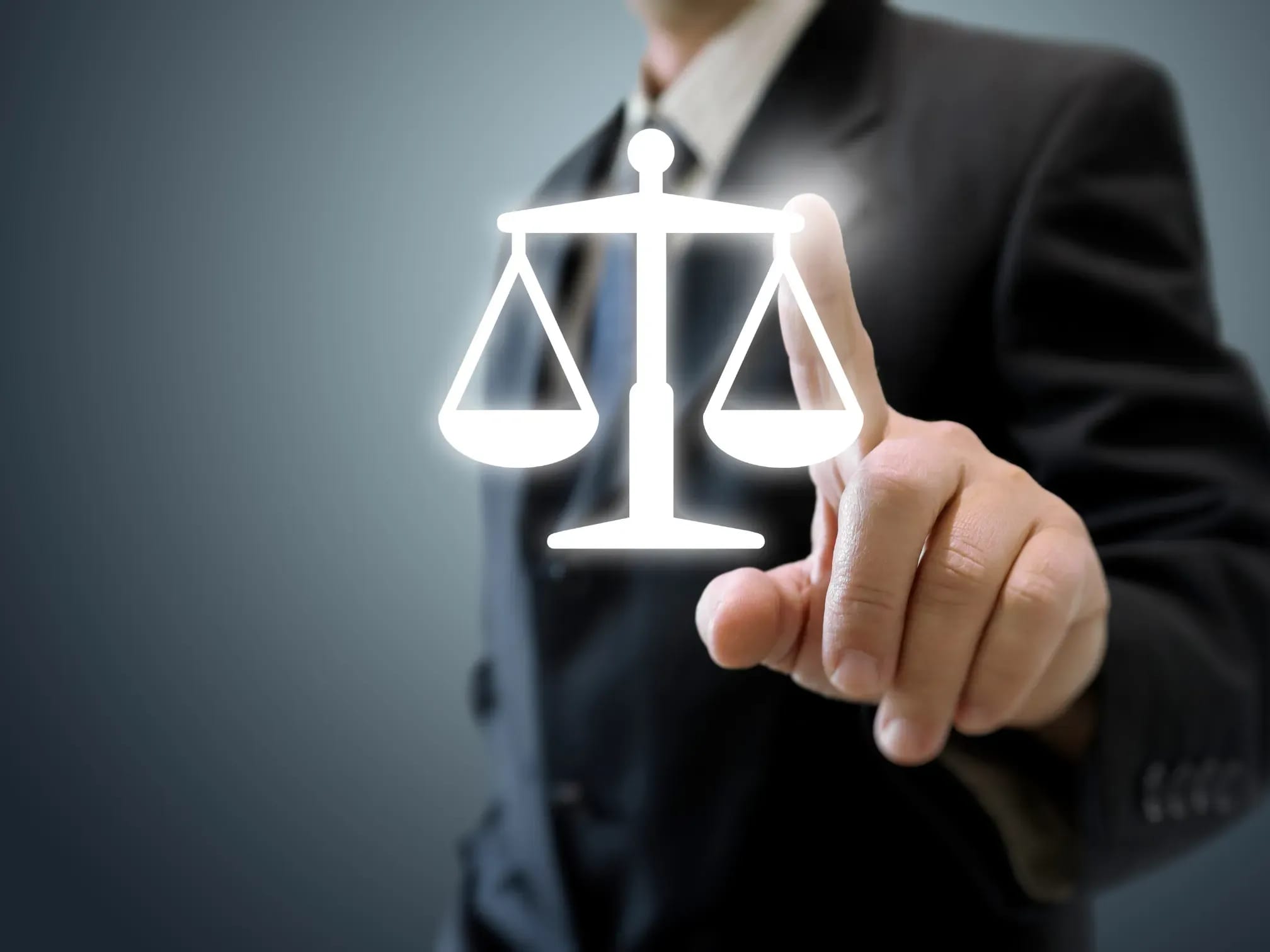Anwalt zeigt mit Finger auf Waage