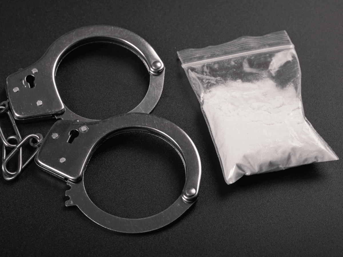 Das Bild zeigt Handschellen und ein Päckchen Kokain